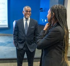 Black man and woman in suits talking at library event