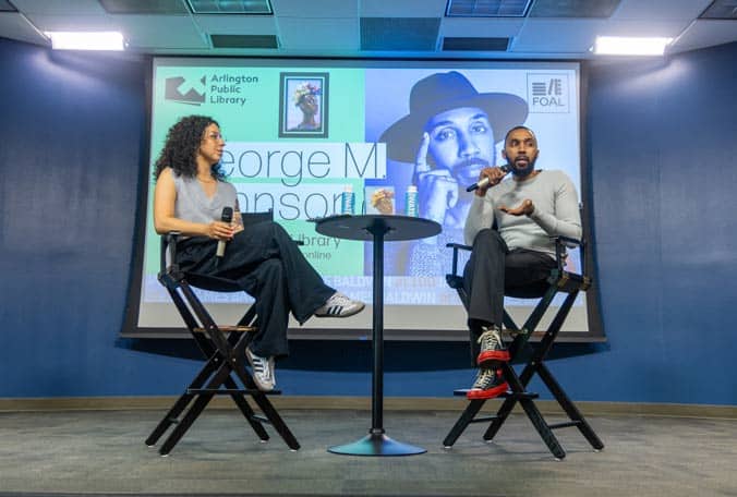 Author and interviewer sitting in chairs on stage at Arlington Public Library Event