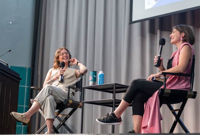 Author and interviewer sitting in chairs on stage at Arlington Public Library Event