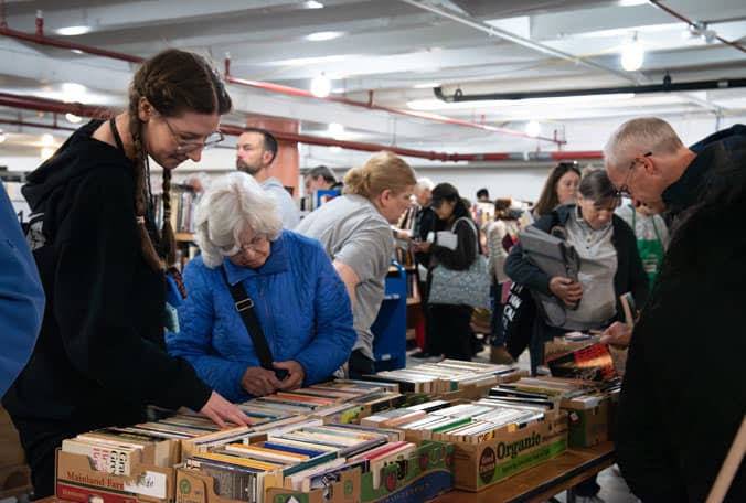 A group of people looking through books at a book sale